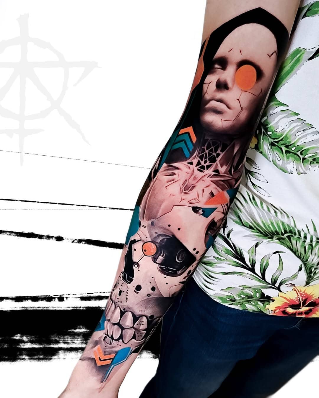 Abstrakcyjny tatuaż rękawa łączący kolorowe symbole i czarno-szare elementy, wykonany przez Adama Ziotewicza w Sztorm Tattoo Gdańsk oraz czaszka najpopularniejszy motyw w tatuażu