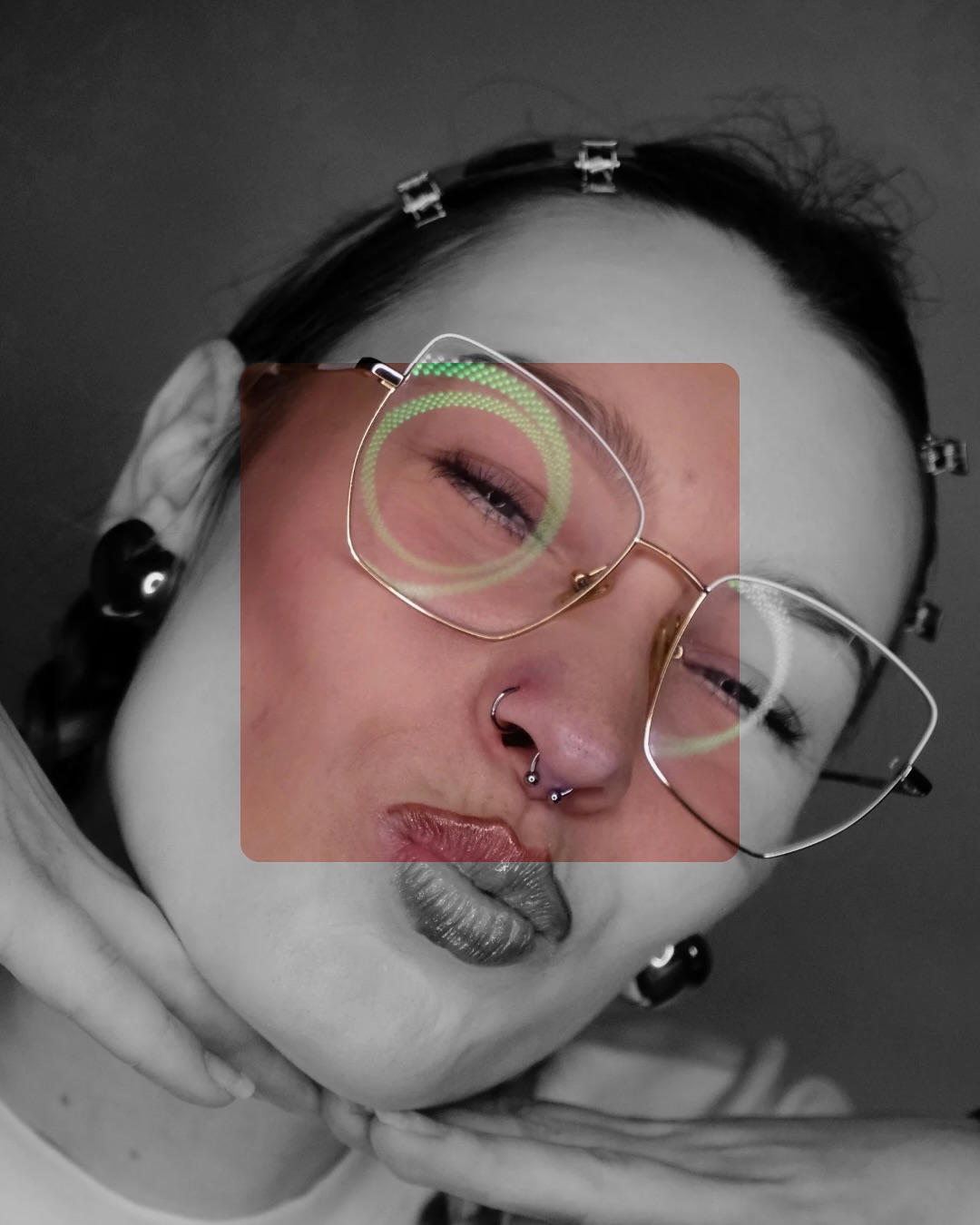 Twarz w okularach z kolczykiem w nosie i ringiem w przegrodzie; ujęcie prezentuje kreatywny piercing twarzy.